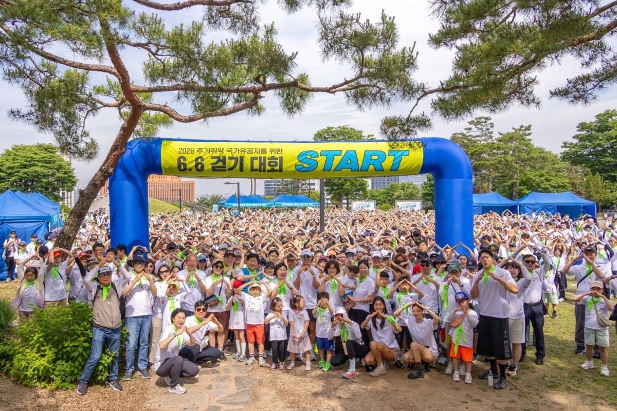 현충일인 지난 6일 서울 중구 남산공원에서 열린 ‘6.6 걷기대회’ 참가자들이 손으로 삼각형 집 모양을 만들고 있다.﻿   한국해비타트 제공