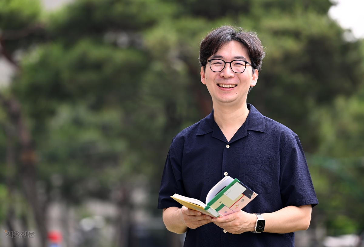 소설가 문지혁이 ‘한국어’ 시리즈의 마지막 ‘실전 한국어’를 펴들고 환하게 웃고 있다. 도준석 전문기자