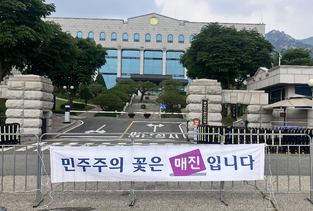 ‘이제석 광고연구소’ 대표로 공익광고 전문가인 이제석 씨가 11일 경기도 과천시 중앙선거관리위원회 앞에서 투표용지 부족 사태를 풍자하는 기습 퍼포먼스를 펼쳤다. 사진은 이 씨가 선관위 앞에 내건 ‘민주주의 꽃은 매진입니다’ 현수막. 2026.6.11. 연합뉴스·이제석 광고연구소 제공