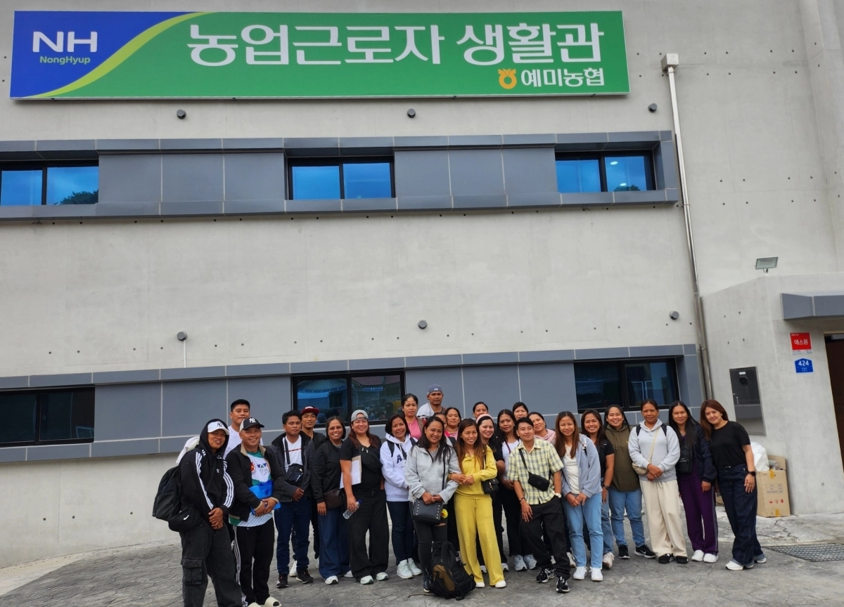 강원 정선지역 농가에서 일하는 외국인 계절근로자들이 공동숙소인 농업근로자 생활관 앞에서 기념촬영을 하고 있다. 정선군 제공