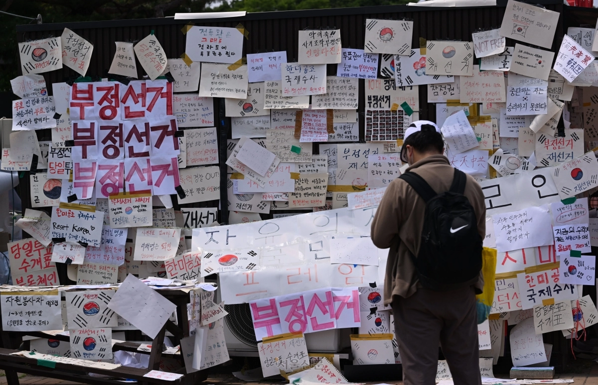 투표용지 부족 사태에 항의하는 개표소 봉쇄 시위가 이어지고 있는 가운데 14일 서울 송파구 올림픽공원 핸드볼경기장 앞에 ‘부정선거’, ‘재선거’ 등 문구가 빼곡하게 붙어 있다. 도준석 전문기자