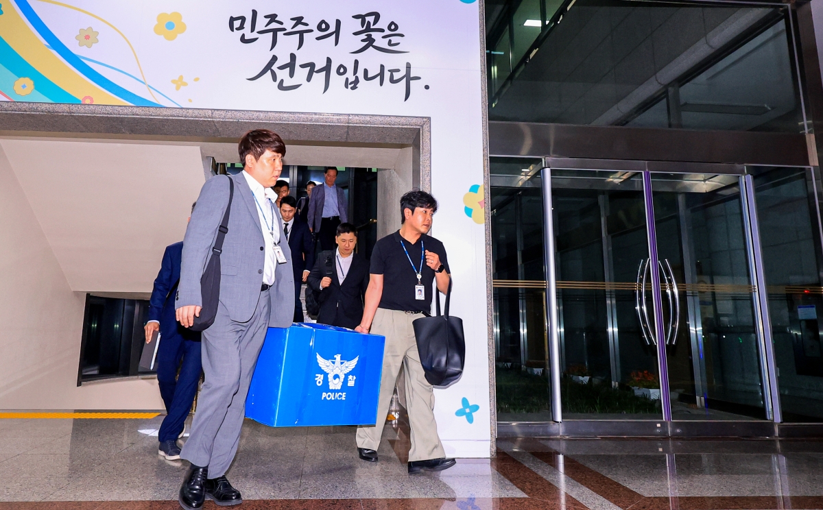 6·3 전국동시지방선거 투표용지 부족 사태를 들여다보고 있는 검경 합동수사본부 관계자들이 11일 경기도 과천 중앙선거관리위원회에서 압수수색을 마친 뒤 압수품을 들고 건물을 나서고 있다. 2026.6.11. 연합뉴스