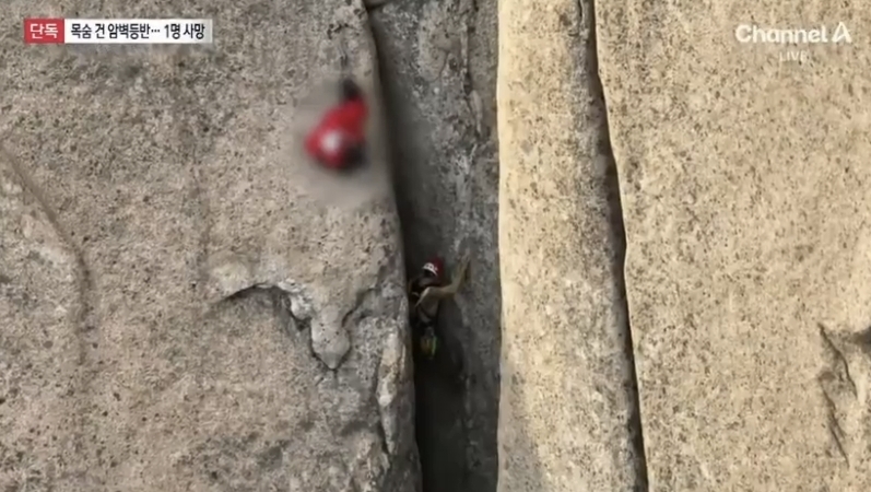 빨간색 점퍼를 입은 고립자를 구하기 위해 특수산악구조대 대원이 맨손으로 암벽을 오르는 모습. 채널A 보도화면 캡처