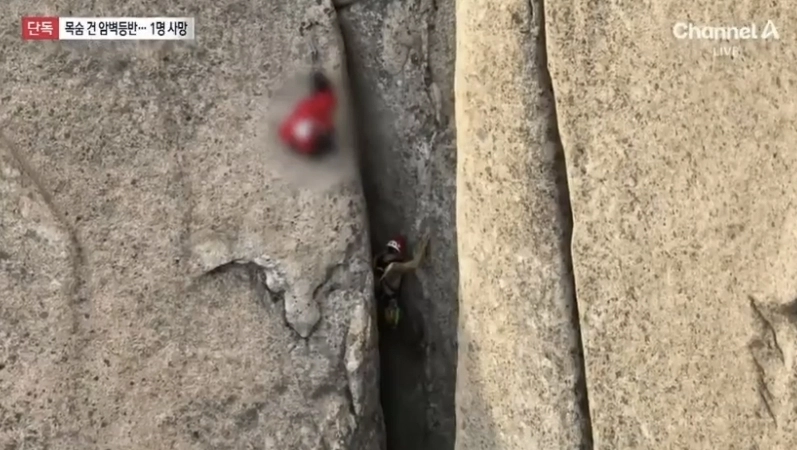 빨간색 점퍼를 입은 고립자를 구하기 위해 특수산악구조대 대원이 맨손으로 암벽을 오르는 모습. 채널A 보도화면 캡처
