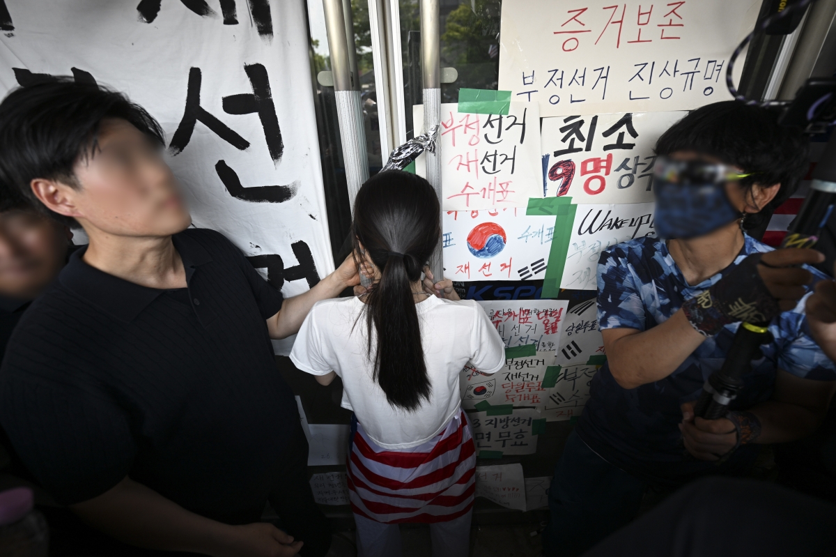 6·3 지방선거 투표용지 부족 사태로 시작한 서울 송파구 올림픽공원 핸드볼경기장 일대 ‘개표소 봉쇄 시위’가 이어지는 가운데 16일 한 시위 참가자가 대한체육회 등 입주 단체 관계자들의 진입을 막아서고 있다. 2026.6.16 공동취재