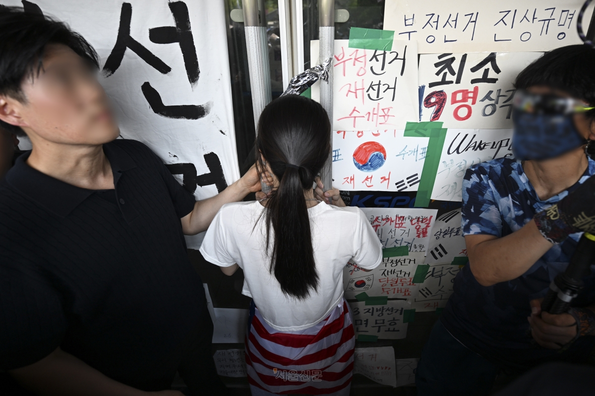 6·3 지방선거 투표용지 부족 사태로 시작한 서울 송파구 올림픽공원 핸드볼경기장 일대 ‘개표소 봉쇄 시위’가 이어지는 가운데 16일 한 시위 참가자가 대한체육회 등 입주 단체 관계자들의 진입을 막아서고 있다. 2026.6.16 홍윤기 기자