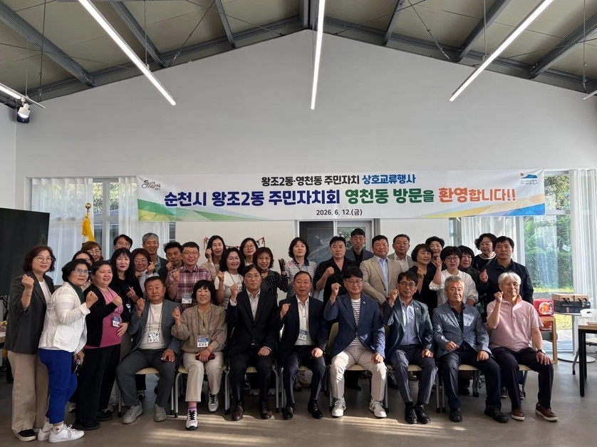 순천시 왕조2동과 서귀포시 영천동 주민자치회가 영천동 자연놀이교실에서 교류 행사 후 기념촬영을 하고 있다.