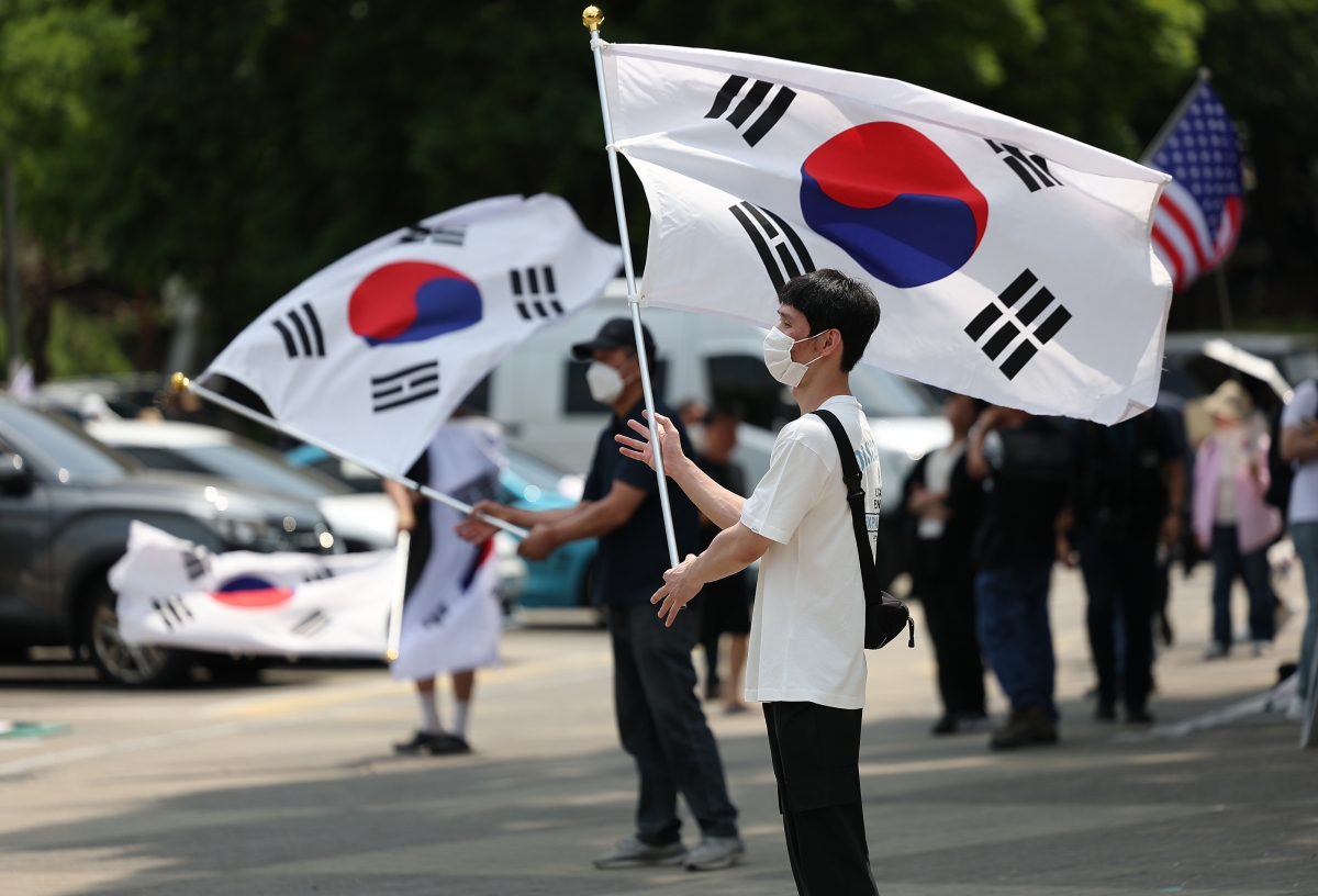 6·3 지방선거 투표용지 부족 사태를 규탄하며 재선거를 요구하는 ‘잠실 개표소 봉쇄 시위’가 계속되고 있는 지난 9일 서울 송파구 올림픽공원 핸드볼경기장에서 참가자들이 태극기를 흔들고 있다. 2026.6.9. 연합뉴스