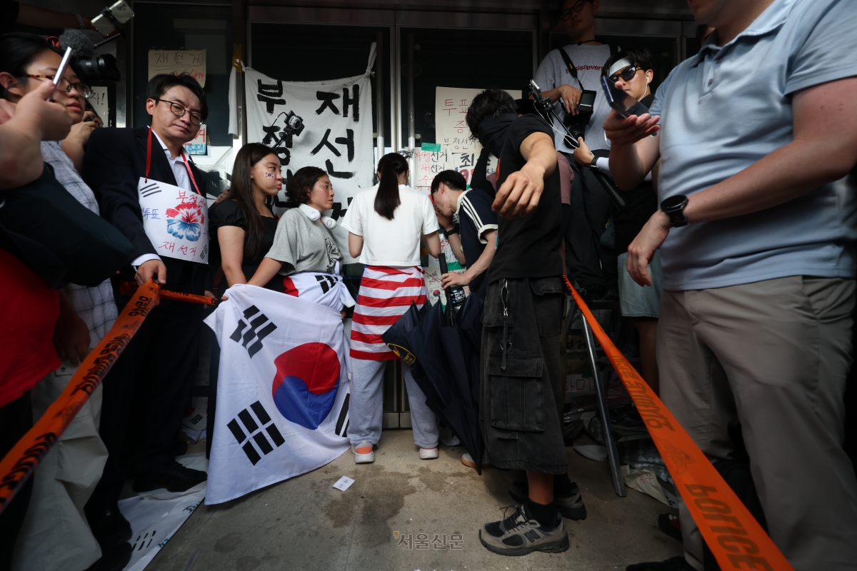 6·3지방선거 투표용지 부족 사태로 촉발된 잠실 개표소 봉쇄 시위가 12일째 이어진 16일 시민들이 서울 송파구 올림픽공원 핸드볼경기장 2-1 출구 앞 문을 지키고 있다. 2026.6.16 홍윤기 기자