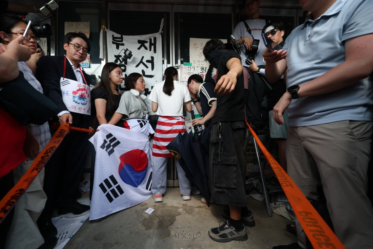 6·3지방선거 투표용지 부족 사태로 촉발된 잠실 개표소 봉쇄 시위가 12일째 이어진 16일 시민들이 서울 송파구 올림픽공원 핸드볼경기장 2-1 출구 앞 문을 지키고 있다. 2026.6.16 홍윤기 기자