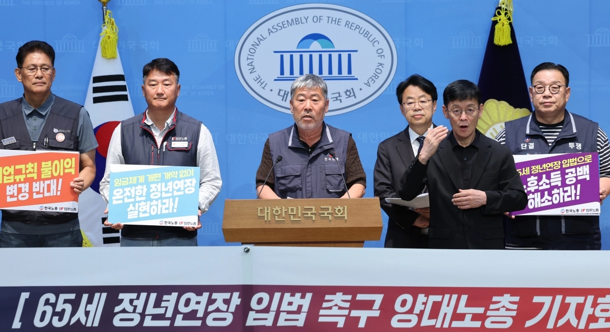김동명(가운데) 한국노총 위원장과 양경수(왼쪽 두 번째) 민주노총 위원장이 지난 16일 서울 여의도 국회 소통관에서 65세 정년연장 입법 촉구 기자회견을 하고 있다.  뉴스1