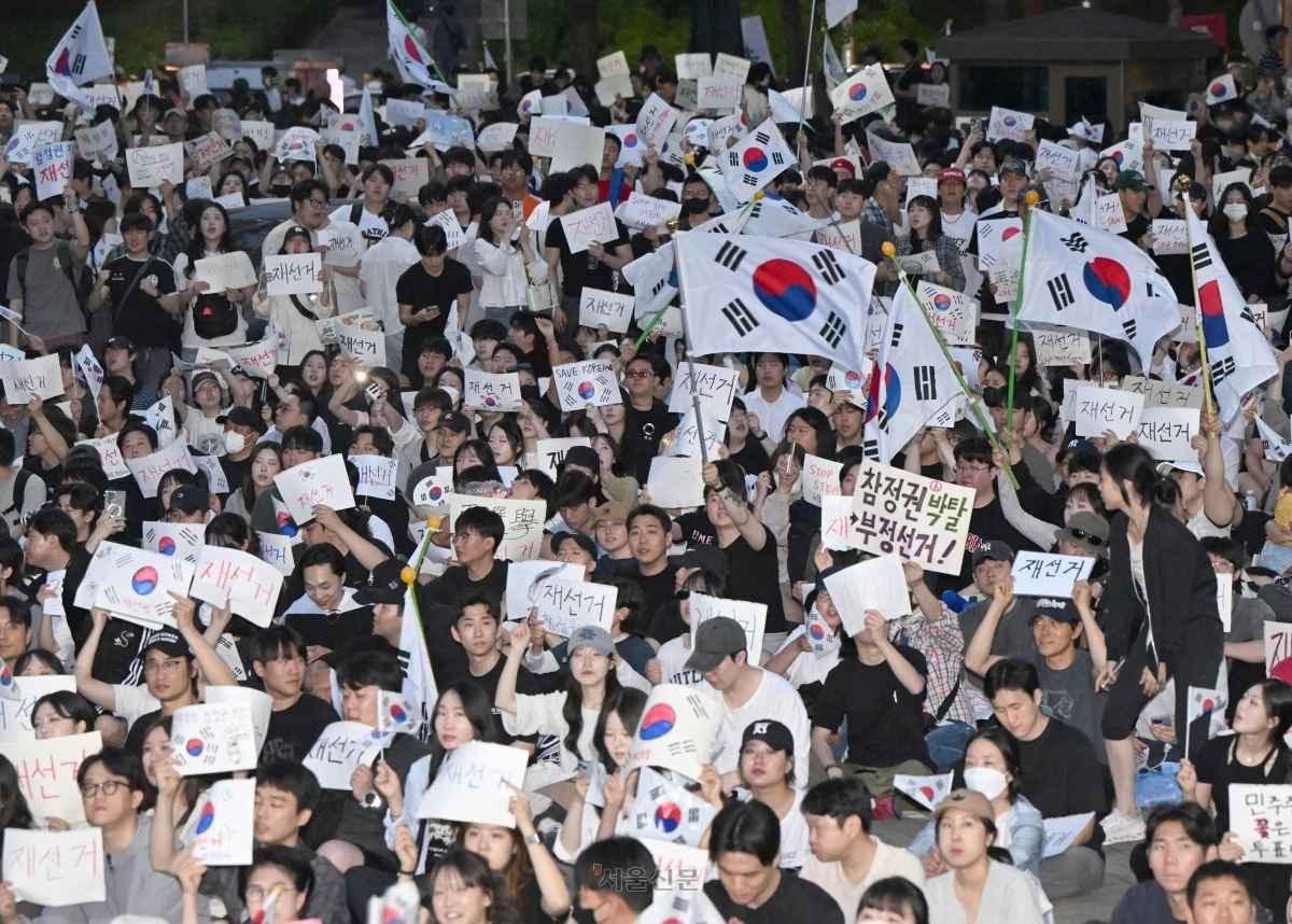 6일 잠실7동 주민들의 개표소인 서울 송파구 올림픽공원 핸드볼경기장 앞에서 시민들이 태극기를 흔들며 재선거를 요구하고 있다. 2026.6.6 이지훈 기자
