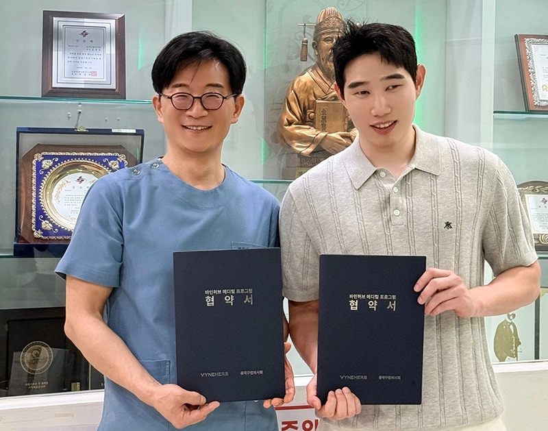 <업무 협약식에서 윤홍일 동작구한의사회 회장(왼쪽)과 강신욱 위글로우 대표(오른쪽)가 협약서를 들고 기념촬영을 하고 있다. 주식회사 위글로우 제공>