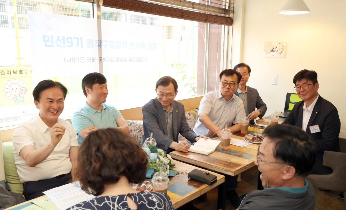 류삼영(왼쪽) 서울 동작구청장 당선인이 18일 사당1동 카페 공방거리 활성화 주민간담회에서 주민들과 이야기하며 웃고 있다. 동작구 제공