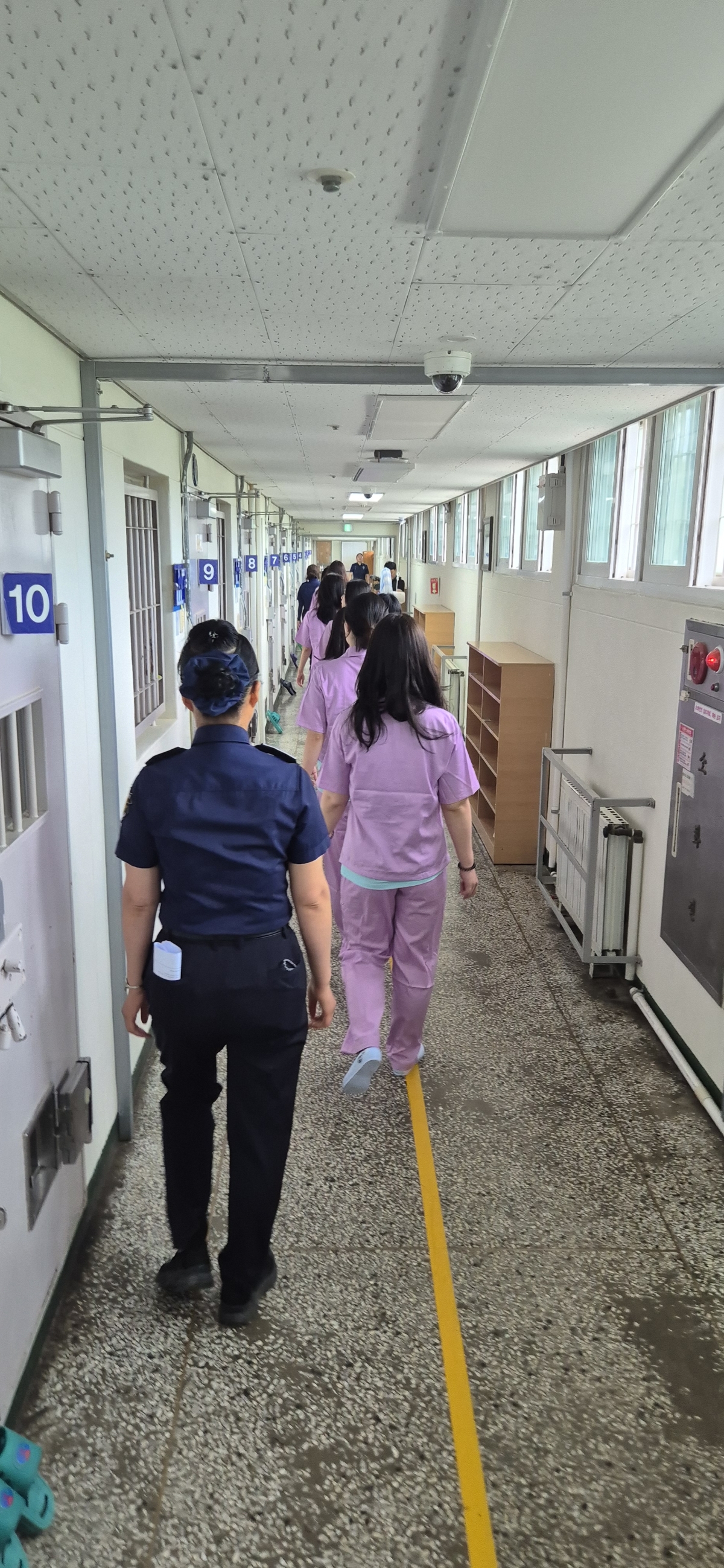 지난 17일 청주여자교도소 수용자 체험에 참석한 기자들이 교도관의 통제를 받으면 수용실로 들어가고 있다. 법무부 제공