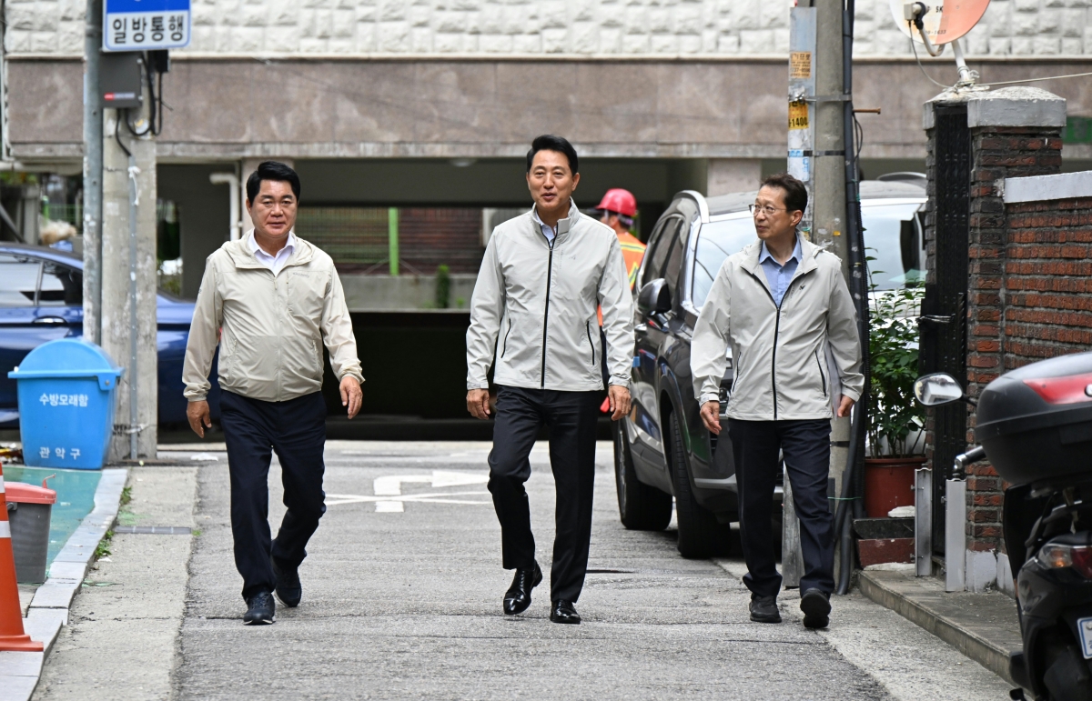 오세훈(가운데) 서울시장과 박준희(왼쪽) 관악구청장이 22일 관악구 일대 침수우려지역의 풍수해 안전대책 시설을 점검하기 위해 이동하고 있다. 서울시 제공