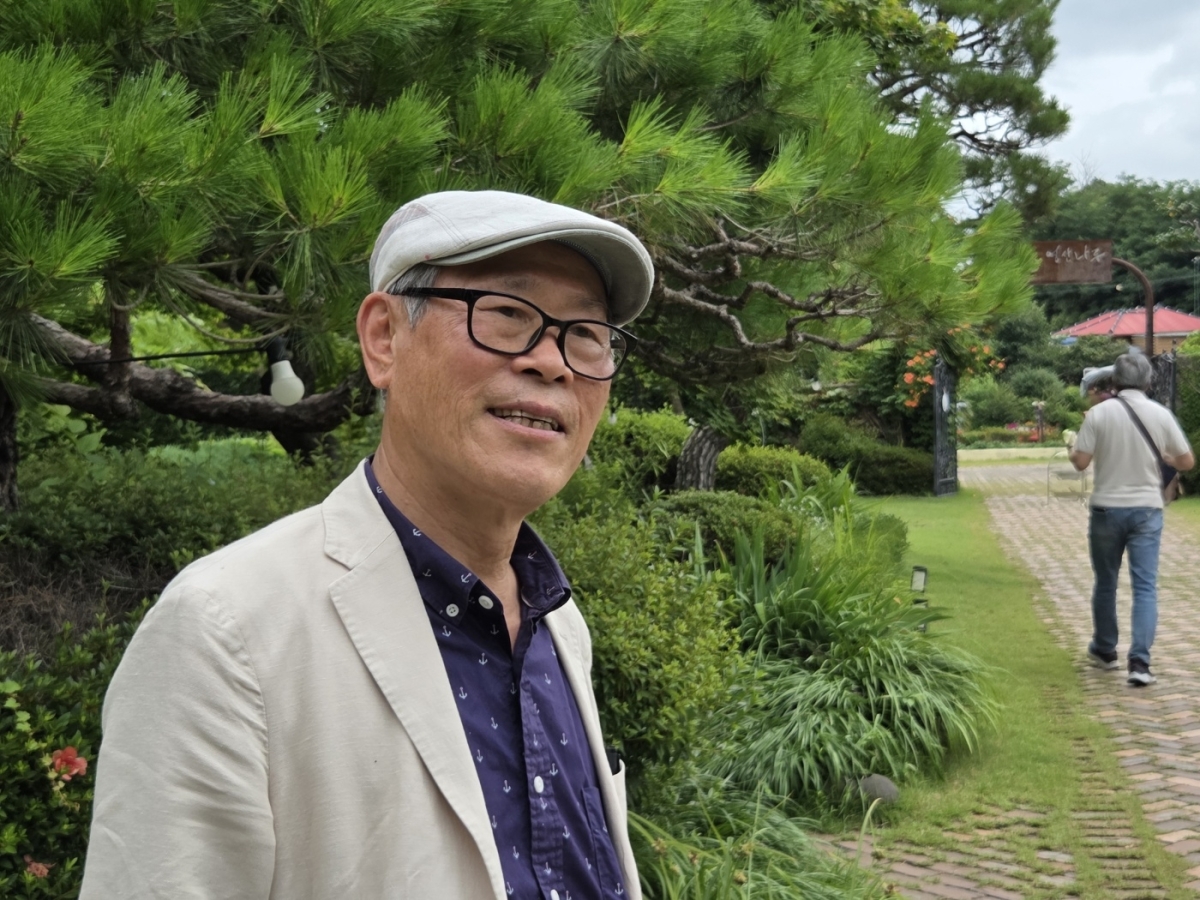 신천운 티월드 회장이  나주시 영산강변 정원 ‘영산나루’에서 포즈를 취하며 차 문화 교류의 의미를 전하고 있다.