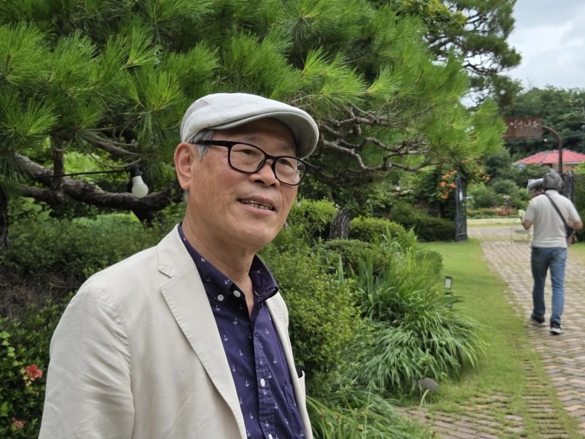 신천운 티월드 회장이  나주시 영산강변 정원 ‘영산나루’에서 포즈를 취하며 차 문화 교류의 의미를 전하고 있다.
