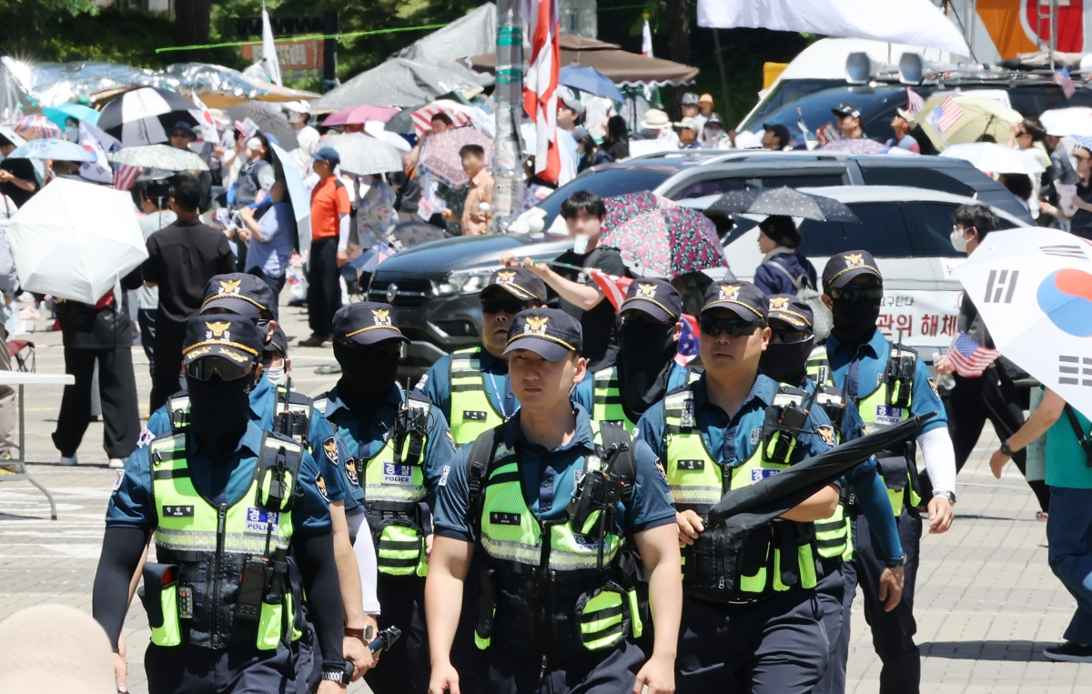 6·3 지방선거 투표용지 부족 사태로 인한 ‘개표소 봉쇄 시위’가 계속되고 있는 23일 서울 송파구 올림픽공원 핸드볼경기장 부근에서 경찰이 근무를 서고 있다. 2026.6.23 연합뉴스