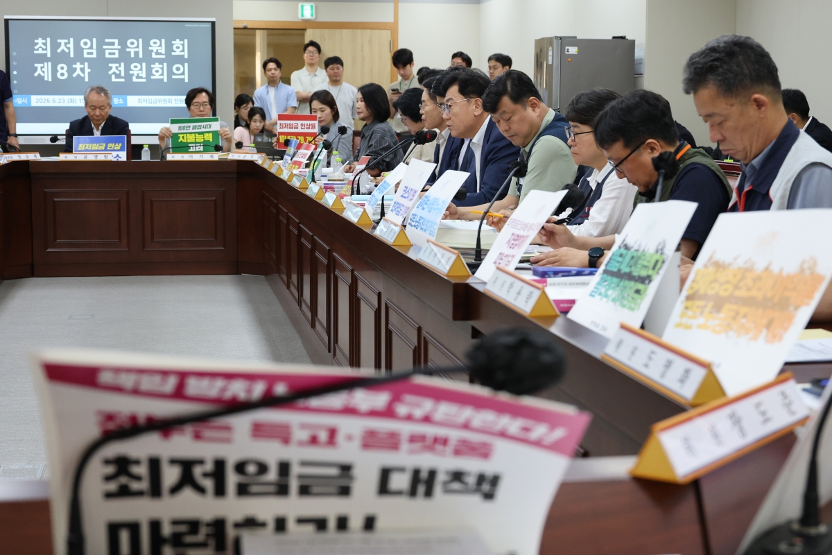 23일 정부세종청사 최저임금위원회에서 내년도 최저임금 인상률을 본격 논의하기 위한 제8차 전원회의가 열리고 있다. 사용자위원과 근로자위원들이 상반된 피켓을 들고 있다. 2026.6.23. 연합뉴스