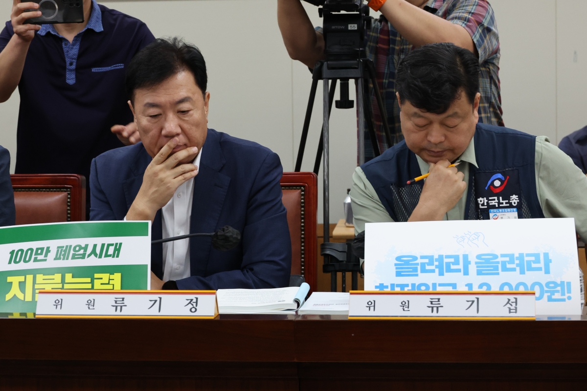23일 정부세종청사 최저임금위원회에서 열린 제8차 전원회의에서 사용자위원인 류기정 한국경영자총협회(경총) 전무(왼쪽)와 근로자위원인 류기섭 한국노총 사무총장이 굳은 표정으로 발언을 듣고 있다. 연합뉴스