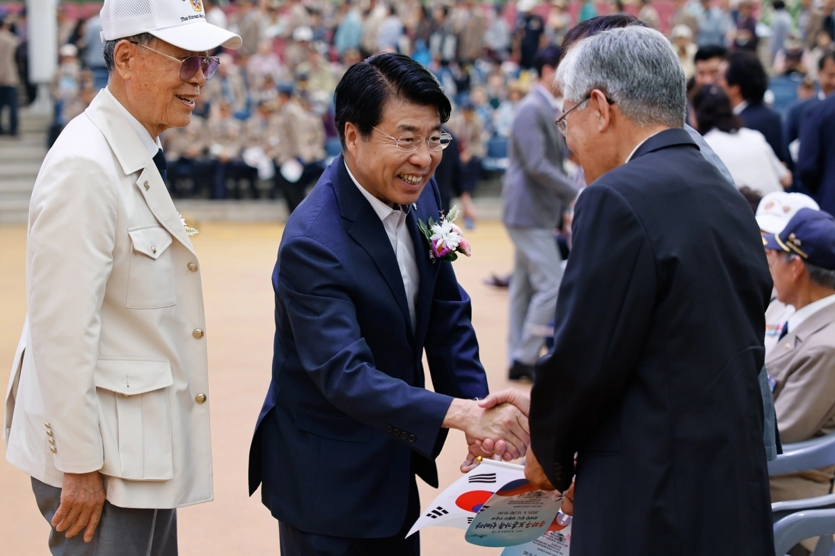 서강석(가운데) 서울 송파구청장이 지난해 6월 12일 서울놀이마당에서 열린 ‘2025 송파구 보훈가족 한마당’에서 국가유공자와 악수하며 인사를 하고 있다. 송파구 제공