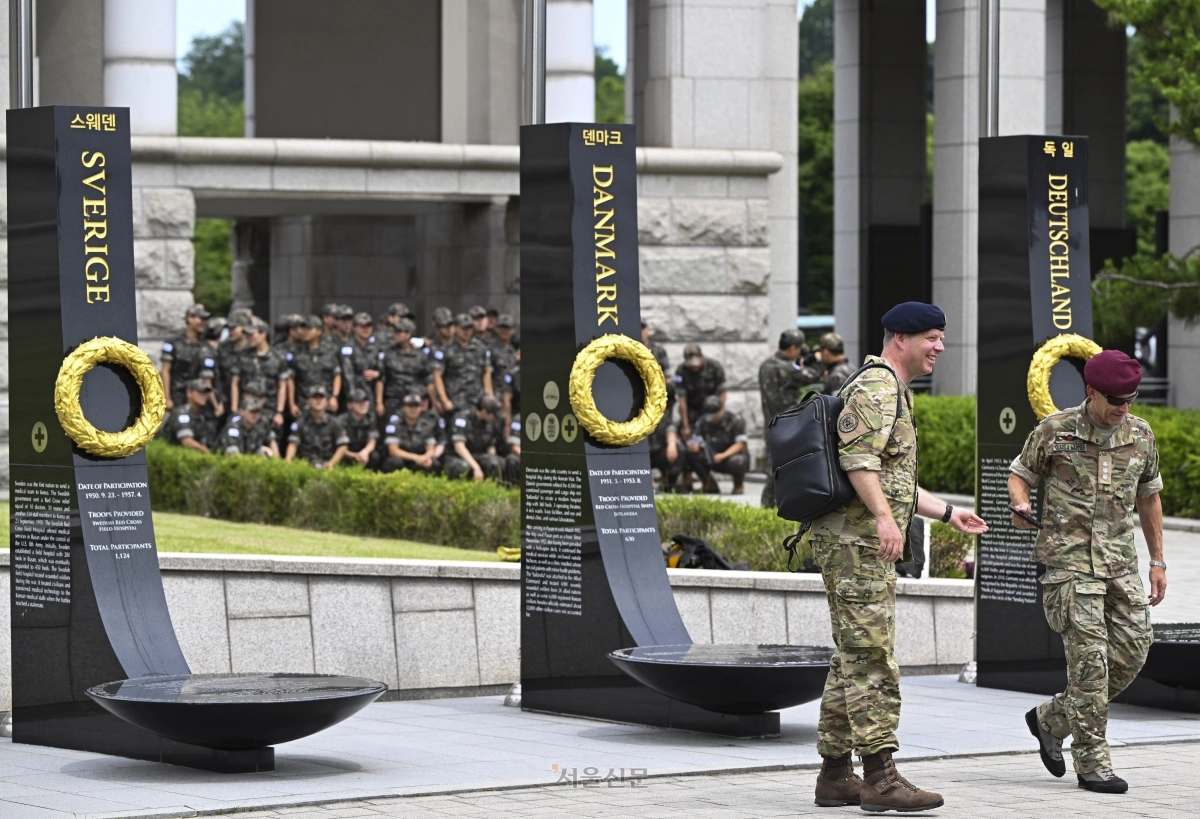 6·25 전쟁 76주년을 하루 앞둔 24일 서울 용산구 전쟁기념관을 찾은 덴마크 군 장병들이 평화의 광장에 마련된 유엔 참전용사 추모비 앞을 지나고 있다. 추모비 너머로 단체 관람을 온 국군 장병들이 보인다. 2026.6.24 이지훈 기자