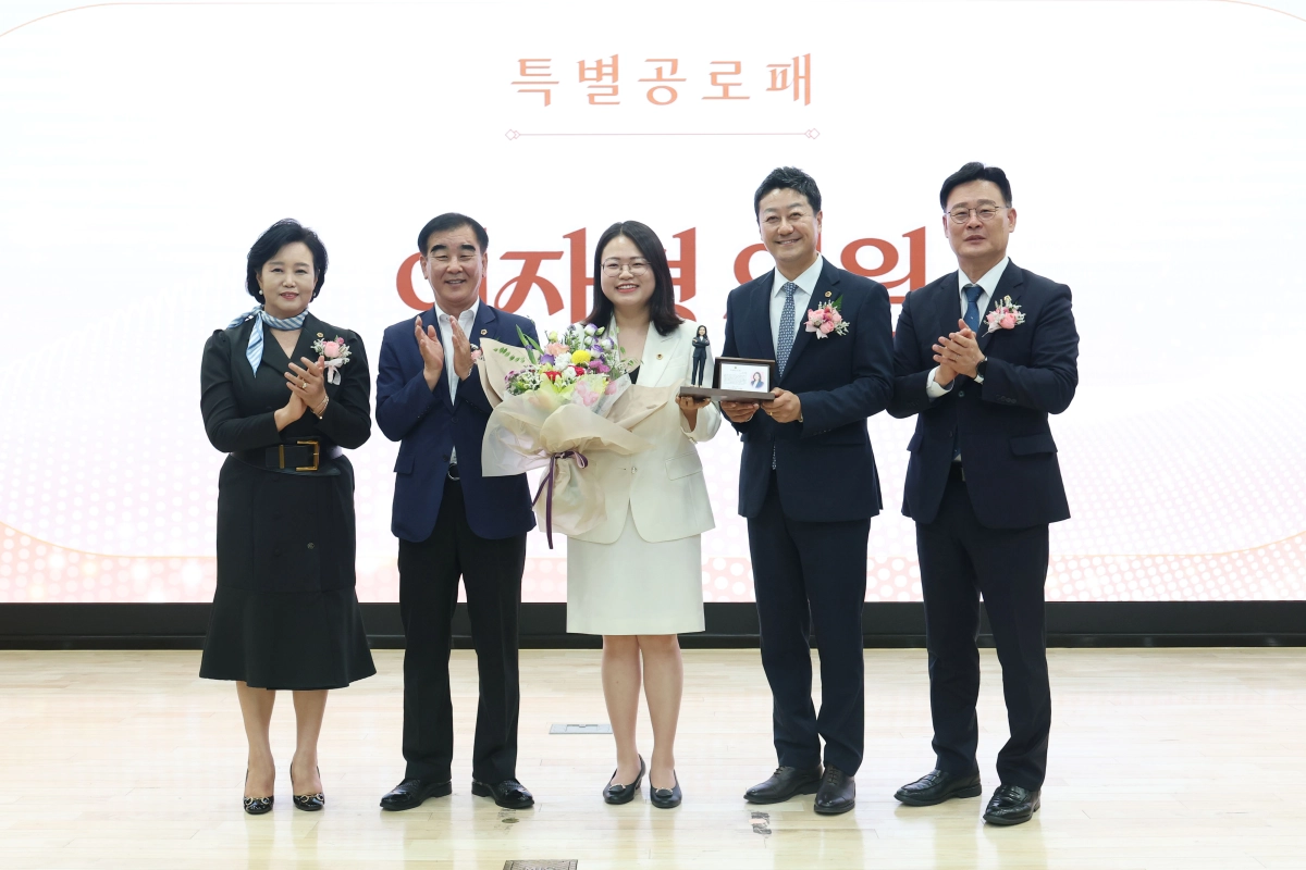▲ 이자형 의원이 24일 경기도의회 대회의실에서 열린 제11대 경기도의회 의원 퇴임식에서 특별공로패와 꽃다발을 수여받은 후 동료 의원들의 축하 속에 기념촬영을 하고 있다. (사진=경기도의회)