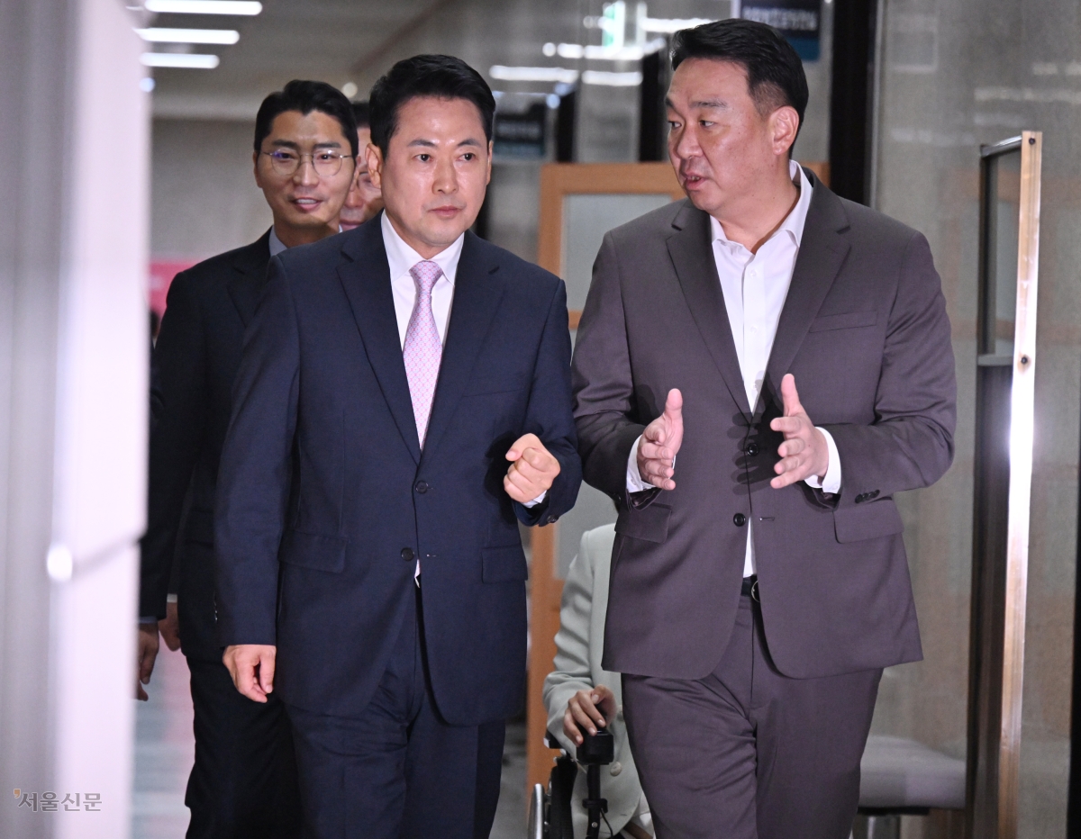 엿새 만에 퇴원한 장동혁(왼쪽) 국민의힘 대표가 24일 국회에서 정희용 사무총장과 대화하며 기자회견장으로 걸어가고 있다. 안주영 전문기자