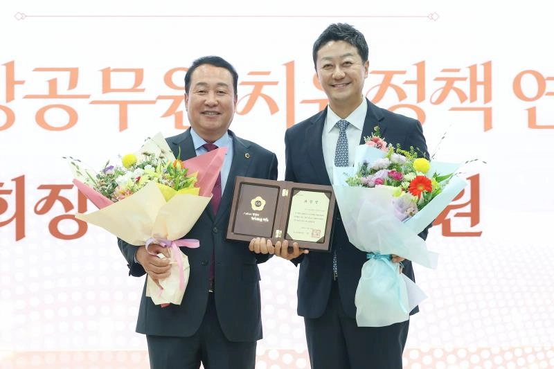 ▲ 경기도의회 퇴임식에서 최우수 연구단체로 선정된 ‘경기도 소방공무원 치유정책 연구회’의 안계일 회장이 상패와 꽃다발을 수여받은 후 기념촬영을 하고 있다. (사진=경기도의회)