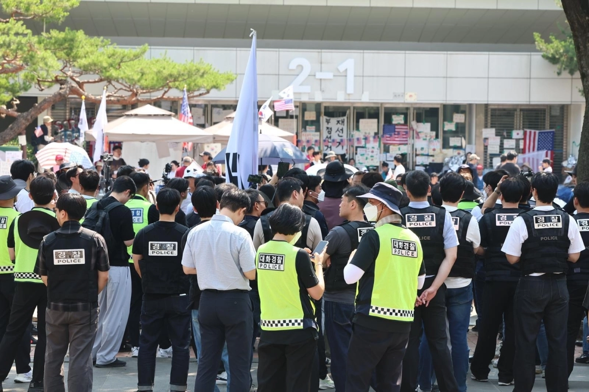 지난 16일 경찰과 대한체육회 등관계자들이 서울 송파구 올림픽공원 핸드볼경기장 진입을 시도하다 시위대와 대치하고 있다. 뉴스1