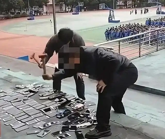 중국의 한 학교에서 압수한 학생 휴대폰을 부수는 교사. 중국 소셜미디어 캡처
