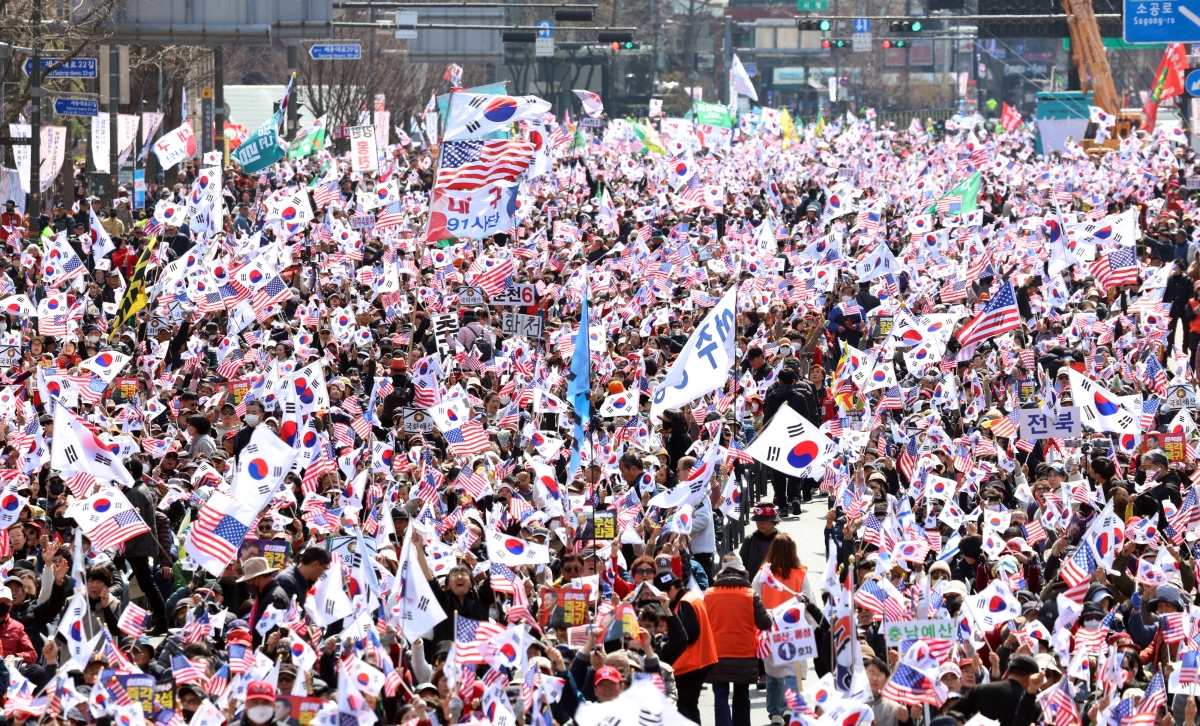 정치화된 극우 개신교 현상은 약 20년 전이다. 저자인 강인철 교수는 정치적으로 성공한 것처럼 보이는 개신교 우파의 정치화는 결국 시민들의 혐오를 불러 일으켜 교세의 약화로 이어질 가능성이 있다고 전망했다. 사진은 2025년 서울 광화문에 모인 대통령 탄핵반대 집회에 모인 참가자들이 태극기와 성조기를 흔들고 있는 모습  뉴스1