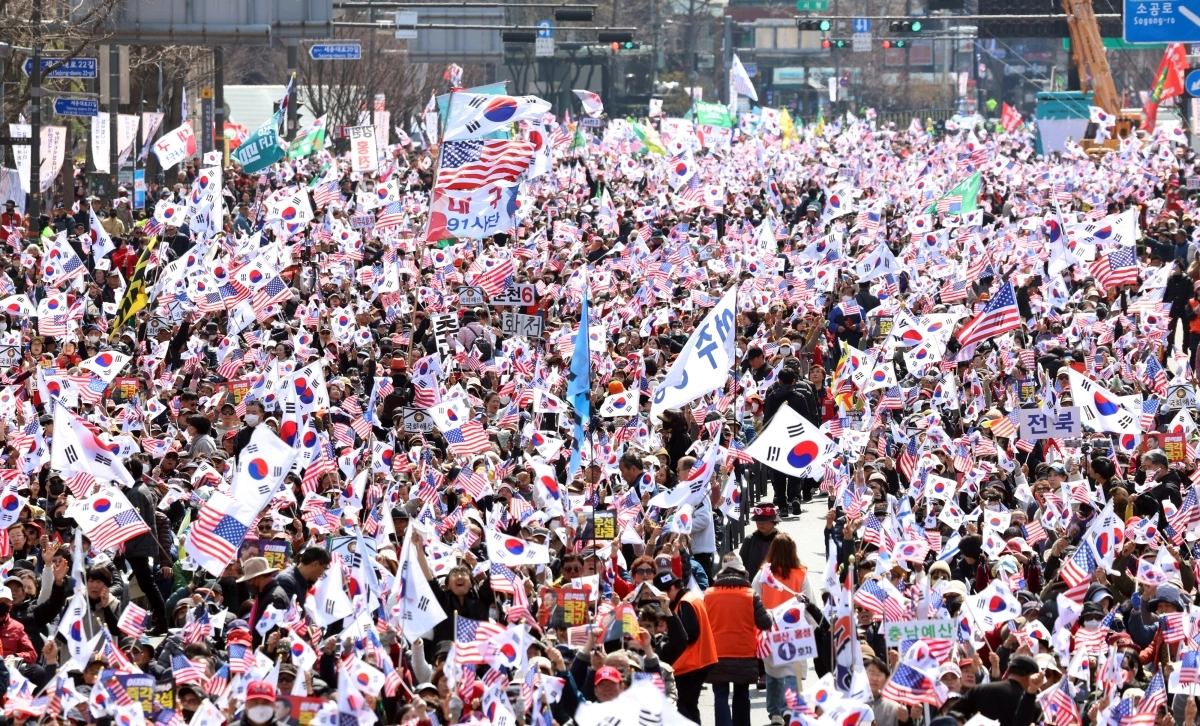 정치화된 극우 개신교 현상은 약 20년 전이다. 저자인 강인철 교수는 정치적으로 성공한 것처럼 보이는 개신교 우파의 정치화는 결국 시민들의 혐오를 불러 일으켜 교세의 약화로 이어질 가능성이 있다고 전망했다. 사진은 2025년 서울 광화문에 모인 대통령 탄핵반대 집회에 모인 참가자들이 태극기와 성조기를 흔들고 있는 모습  뉴스1