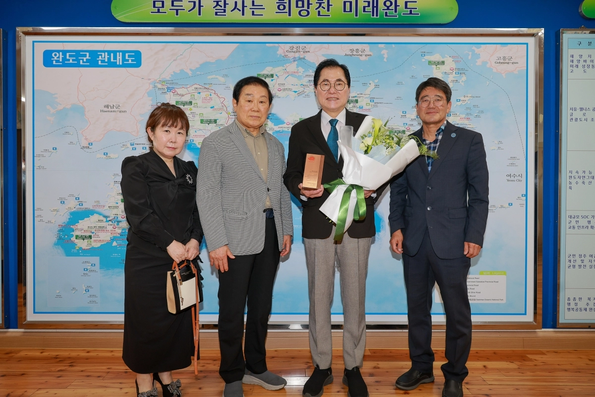 신우철 완도군수가 국제슬로시티연맹으로부터 공로패를 받고 기념촬영을 하고 있다.