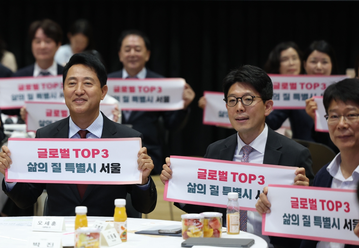 오세훈(왼쪽 첫 번째) 서울시장과 김병민(가운데) G3 서울 기획위원회 공동위원장이 29일 시청에서 열린 G3 서울 기획위원회 발대식에서 ‘글로벌 탑3 삶의 질 특별시 서울’이라고 적힌 타올을 펼쳐 드는 퍼포먼스를 하고 있다. 연합뉴스