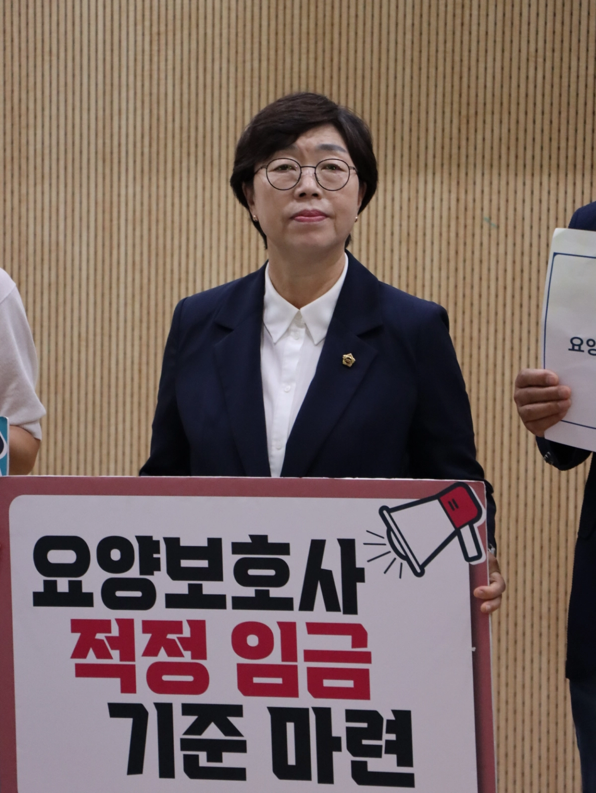 ▲ 박옥분 의원이 경기도의회 브리핑룸에서 경기도 내 요양보호사의 적정 임금 기준 마련과 처우 개선을 촉구하는 피켓을 들고 있다. (사진=경기도의회)