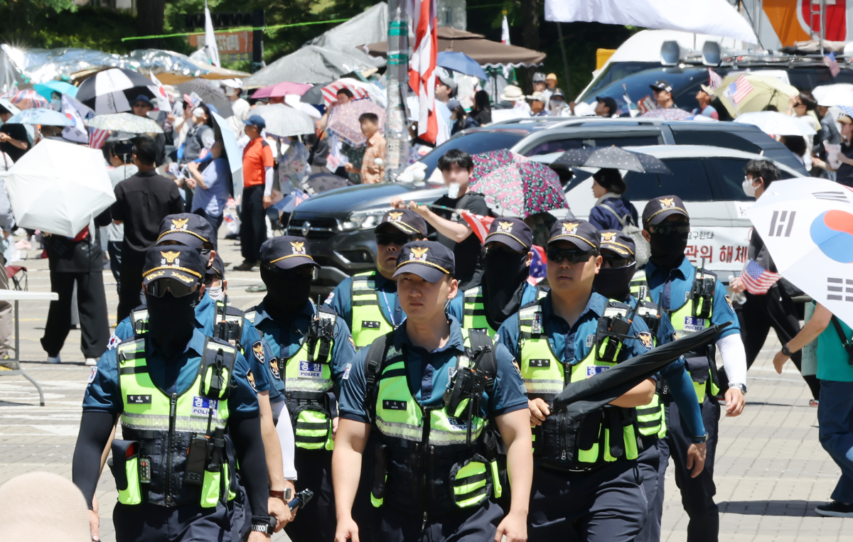 6·3 지방선거 투표용지 부족 사태로 인한 ‘개표소 봉쇄 시위’가 계속되고 있는 23일 서울 송파구 올림픽공원 핸드볼경기장 부근에서 경찰이 근무를 서고 있다. 연합뉴스
