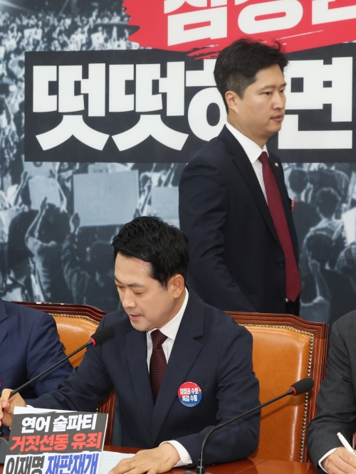 장동혁(아래) 국민의힘 대표가 29일 최고위원회의를 주재하기 위해 앉아 있는 뒤쪽으로 우재준 최고위원이 입장하고 있다. 우 최고위원은 이날도 공개적으로 장 대표의 사퇴를 촉구했다. 뉴스1