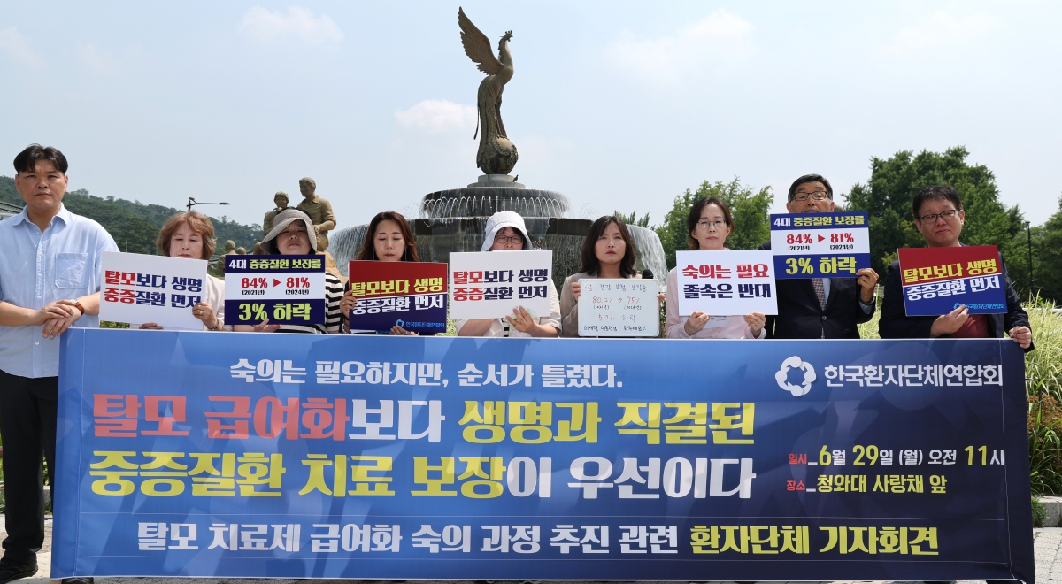 한국환자단체연합회 관계자들이 29일 서울 종로구 청와대 분수대 앞에서 기자회견을 열고 “탈모 급여화보다 생명과 직결된 중증질환 치료보장이 우선이다”라며 정부의 탈모치료제 급여화 사회적 숙의 과정 추진에 대한 입장을 밝히고 있다.
