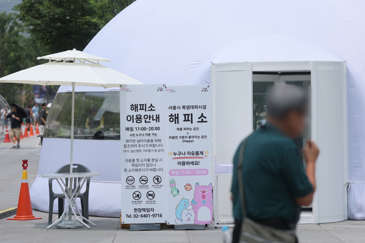 무더운 날씨가 이어진 29일 서울 광화문광장에 설치된 서울시 폭염대피시설 ‘해피소’에서 시민들이 더위를 식히고 있다. 연합뉴스