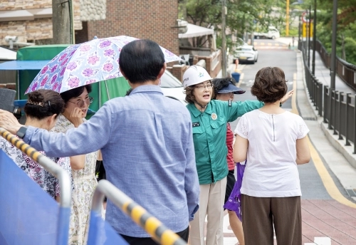박희영 용산구청장이 지난 29일 민선 8기 역점사업인 용암초등학교 앞 도로 열선 설치 공사 현장에서 주민과 이야기를 나누고 있다.  용산구 제공