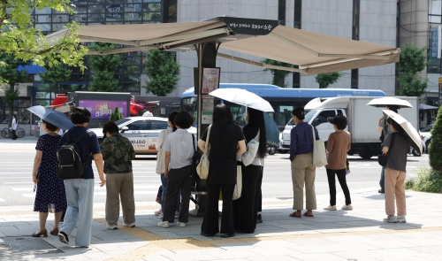 서울 노원구 횡단보도 그늘막에서 시민들이 뜨거운 햇볕을 피하고 있다.  노원구 제공