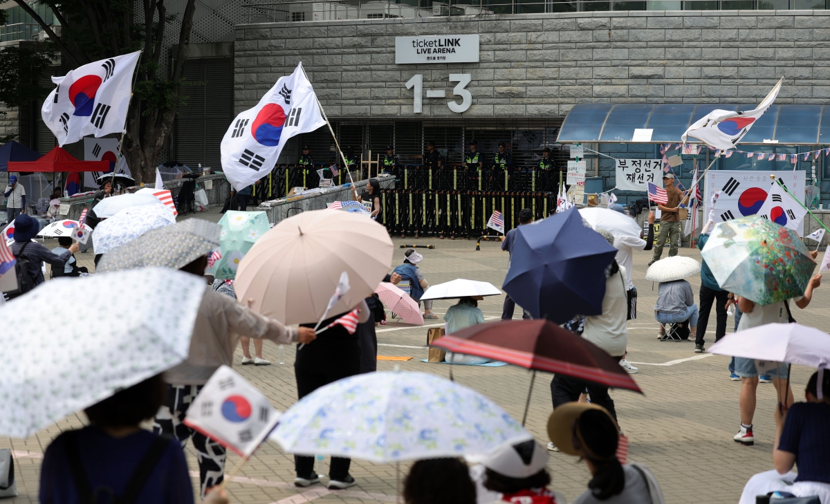 투표용지 부족 사태에 항의하는 개표소 봉쇄 시위가 26일째 이어지고 있는 30일 오후 서울 송파구 올림픽공원 핸드볼경기장 앞에서 참가자들이 태극기와 성조기를 흔들며 “부정선거, 재선거, 당일투표, 수개표”를 외치고 있다. 2026.06.30.  뉴시스