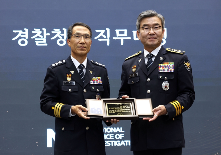 박성주 국가수사본부장(오른쪽)이 30일 서울 서대문구 경찰청에서 열린 퇴임식에서 유재성 경찰청장 직무대행으로부터 재직기념패를 받고 기념촬영하고 있다. 2026.6.30  연합뉴스