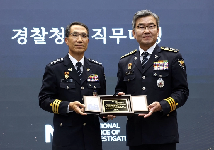 박성주 국가수사본부장(오른쪽)이 30일 서울 서대문구 경찰청에서 열린 퇴임식에서 유재성 경찰청장 직무대행으로부터 재직기념패를 받고 기념촬영하고 있다. 2026.6.30  연합뉴스