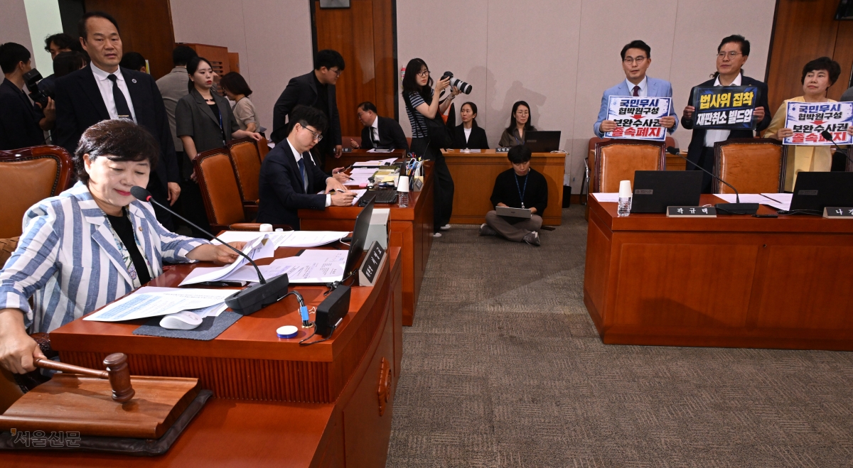 서영교(왼쪽) 국회 법제사법위원장이 8일 법사위 전체회의를 주재하는 동안 국민의힘 의원들이 일방적 원구성과 검찰 보완수사권 폐지에 항의하는 피켓 시위를 벌이고 있다. 오른쪽부터 국민의힘 조배숙, 송석준, 윤상현 의원. 안주영 전문기자