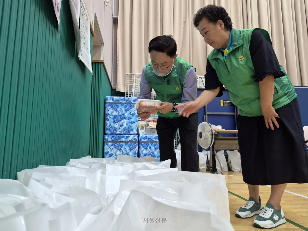 최기찬(왼쪽) 서울 금천구청장이 9일 시흥2동 금천종합복지타운에서 어르신을 위해 준비된 밑반찬을 확인하고 있다.