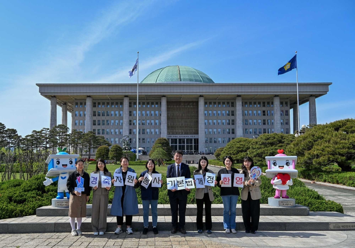 자원봉사 관계자들이 국회의사당 앞에서 ‘자원봉사기본법’ 전부개정을 환영하는 문구를 들고 기념촬영을 하고 있다. 한국중앙자원봉사센터 제공