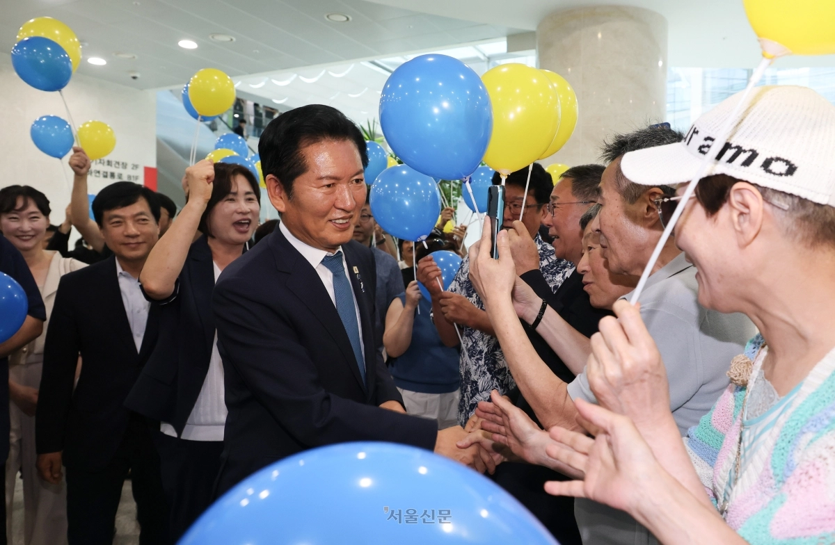 정청래(가운데) 더불어민주당 전 대표가 13일 국회 소통관에서 8·17 전당대회 당대표 출마선언을 한 뒤 노랑·파랑 풍선을 든 지지자들과 악수를 하고 있다. 안주영 전문기자